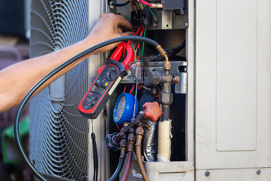 HVAC technician servicing an air conditioning unit in Greenwood, IN